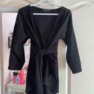 In good condition lightest worn. Black fabric with long sleeves and a tie waist